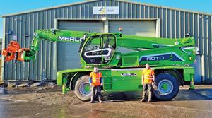 Tivoli employees standing in front of warehouse with large Merlo Roto machine